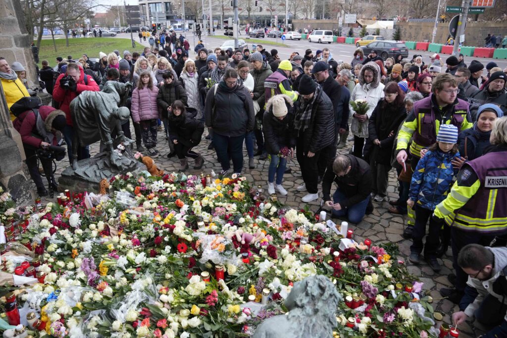 Citizens pay tribute for deaths outside St. John's Church near a Christmas Market, where a car drove into a crowd on Friday evening, in Magdeburg, Germany, Saturday, Dec. 21, 2024. (AP Photo/Ebrahim Noorozi)