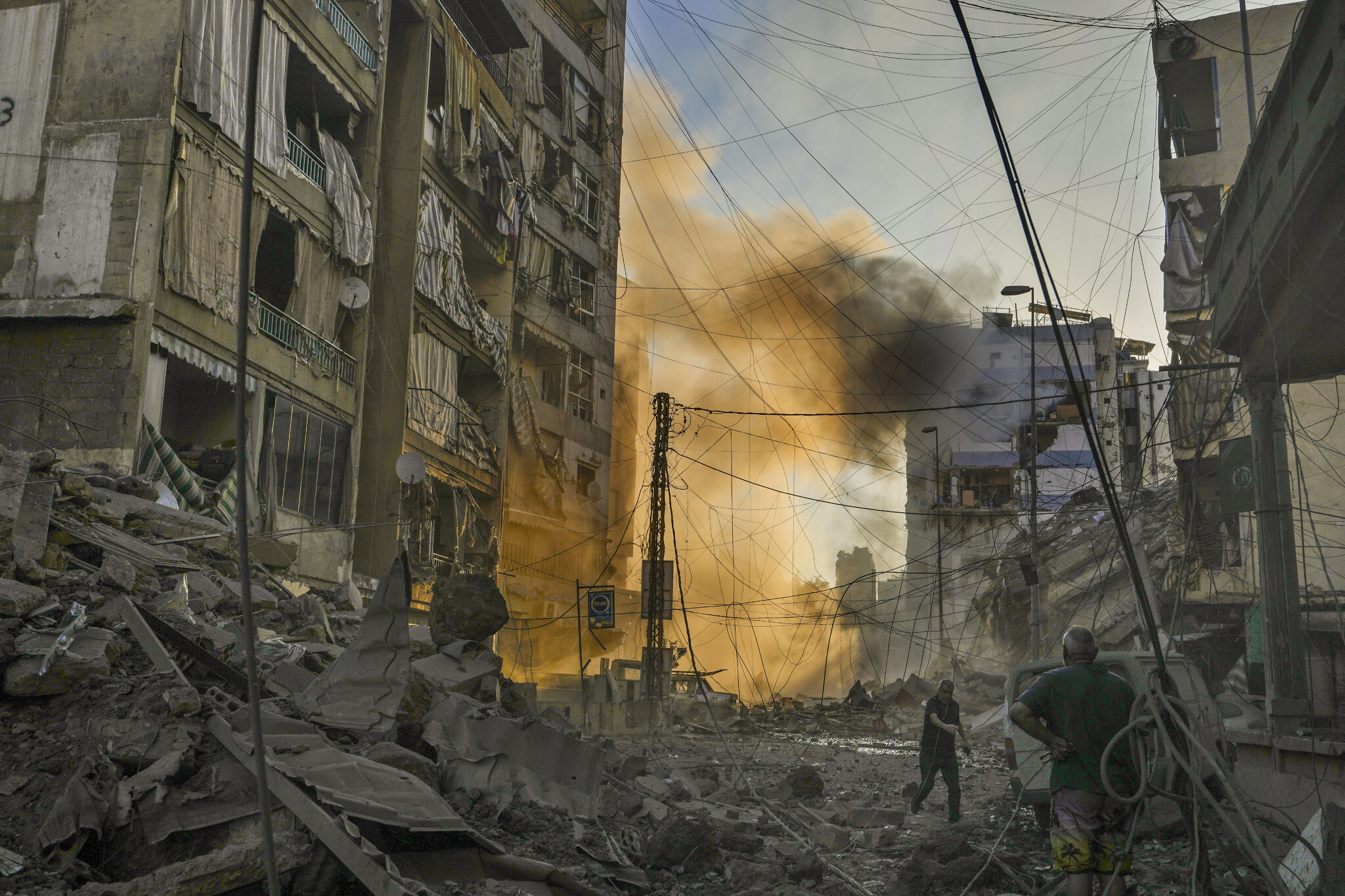 A man runs for cover as a smoke raises in the background following an Israeli airstrike in Dahiyeh, Beirut, Lebanon, Friday, Oct. 4, 2024. (AP Photo/Hassan Ammar)