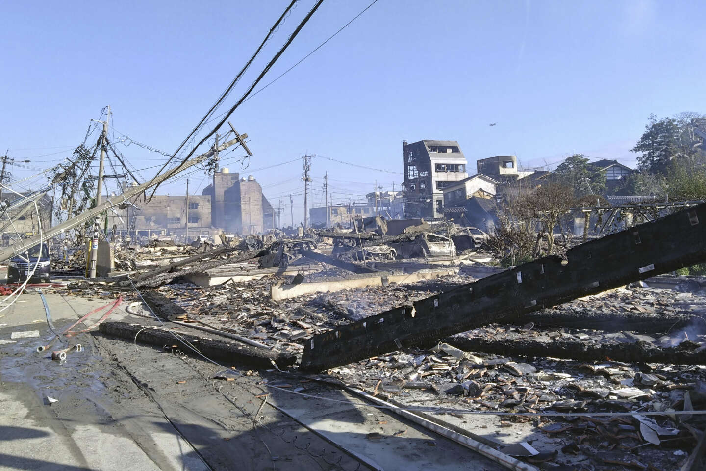 Debris are seen at the site of a fire occurred following an earthquake in Wajima, Ishikawa prefecture, Japan Tuesday, Jan. 2, 2024. A series of powerful earthquakes in western Japan left at least four people dead and damaged homes, cars and boats, with officials warning people on Tuesday to stay away from their homes in some areas because of a continuing risk of major quakes and tsunamis. (Kyodo News via AP)