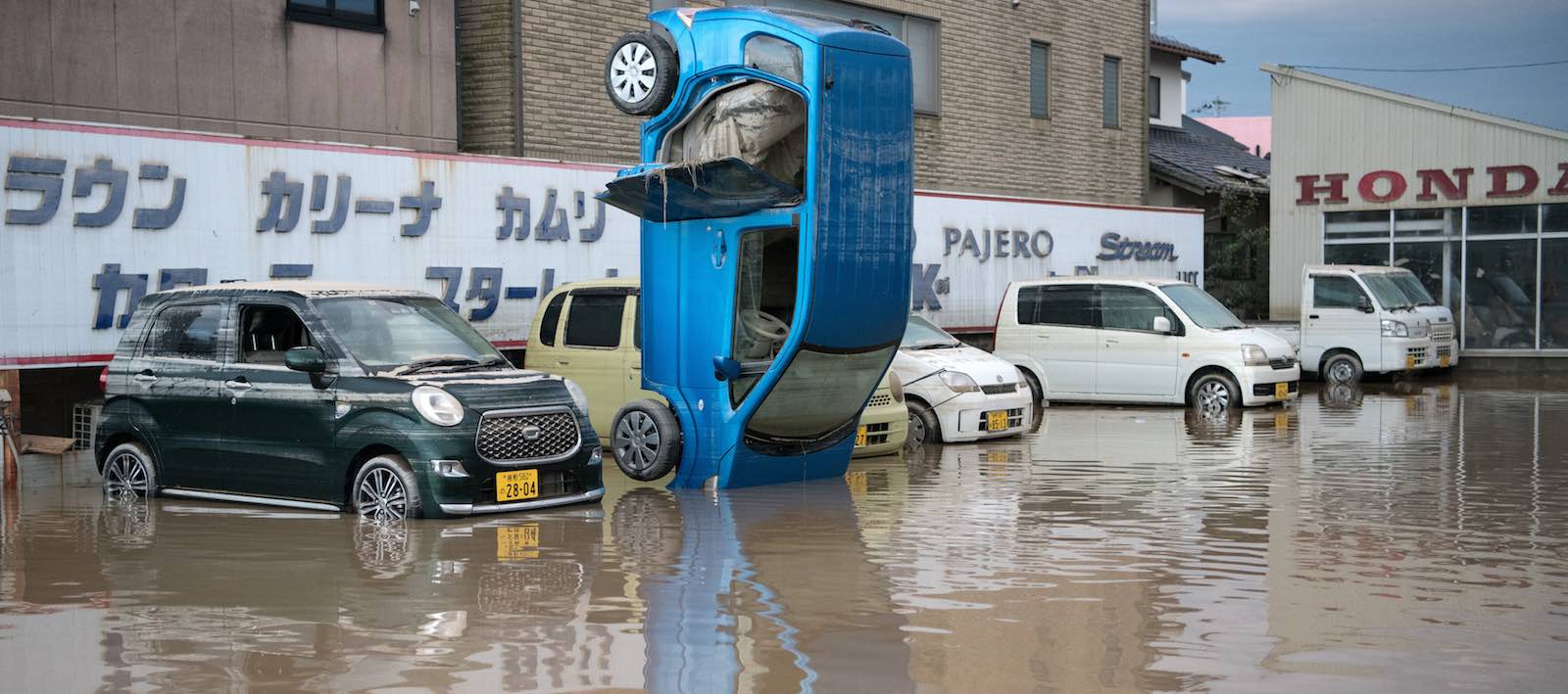 OKAYAMA, JAPAN - JULY 08: A car stands on its front following heavy flooding, on July 8, 2018 in Kurashiki near Okayama, Japan. Over 70 people have died and dozens are missing in Japan as torrential rain caused flash flooding and landslides across central and western parts of the country while more than two million people have been ordered to evacuate. (Photo by Carl Court/Getty Images)