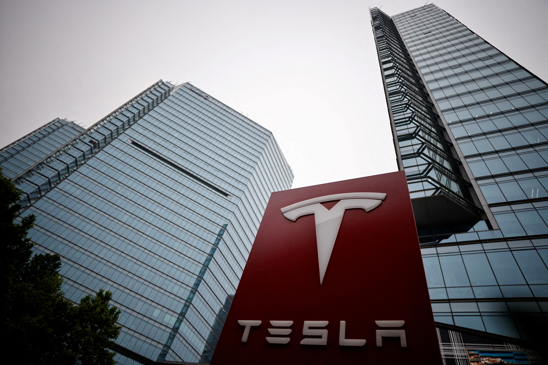 FILE PHOTO: A Tesla logo is seen outside a showroom of the carmaker in Beijing, China May 31, 2023. REUTERS/Thomas Peter