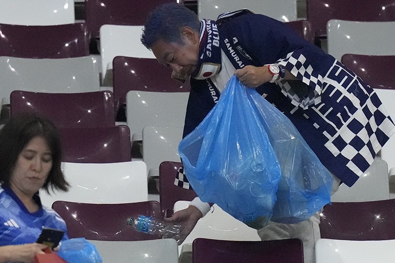 Japan supporters clean the stands at the end of the World Cup group E soccer match between Germany and Japan, at the Khalifa International Stadium in Doha, Qatar, Wednesday, Nov. 23, 2022. Japan won 2-1.(AP Photo/Eugene Hoshiko)